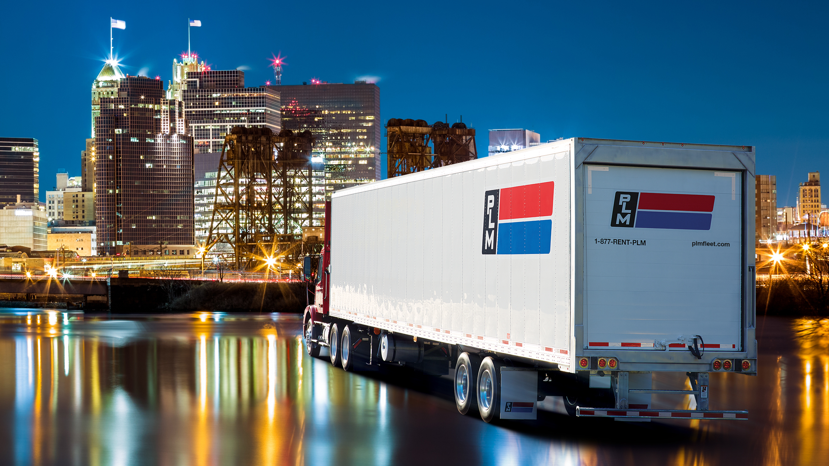 PLM Fleet refrigerated trailer in front of a night time Newark, NJ timeline where the PLM Fleet headquarters are located.