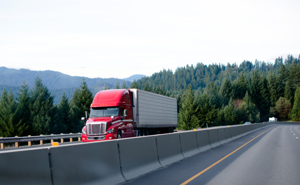 refrigerated truck driving down road - Getty Image